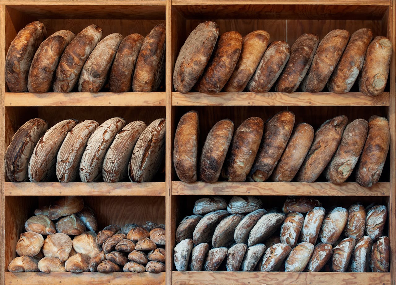The Art of Drawing Readers In: Your attractive post title goes here A variety of artisanal breads neatly arranged on wooden shelves, creating a rustic display.